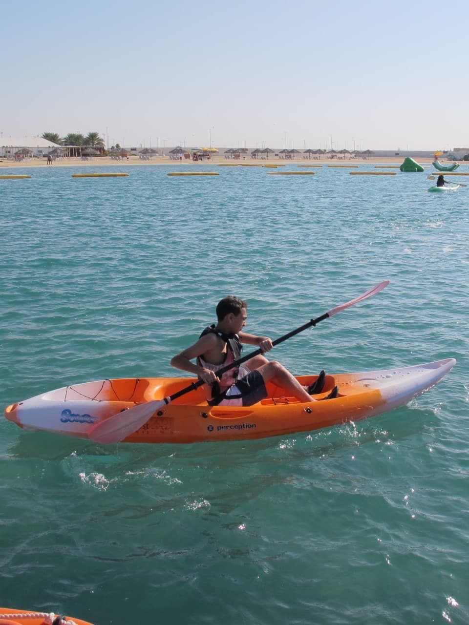 Kayaker paddling along a calm stretch of coastline.